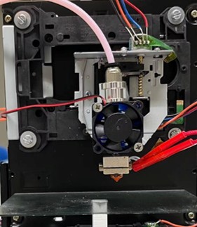 Close-up of hotend assembly mounted on repurposed CD drive carriage with cooling fan